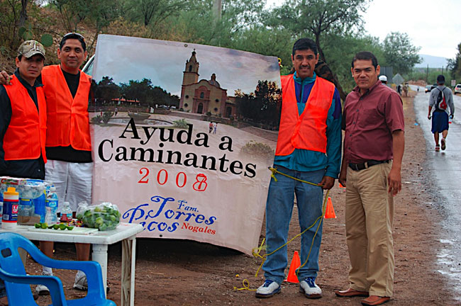 Members of the Torres Picos family offer their support to walkers with water, lemons, and medicines. (George Thomson/Borderzine.com)