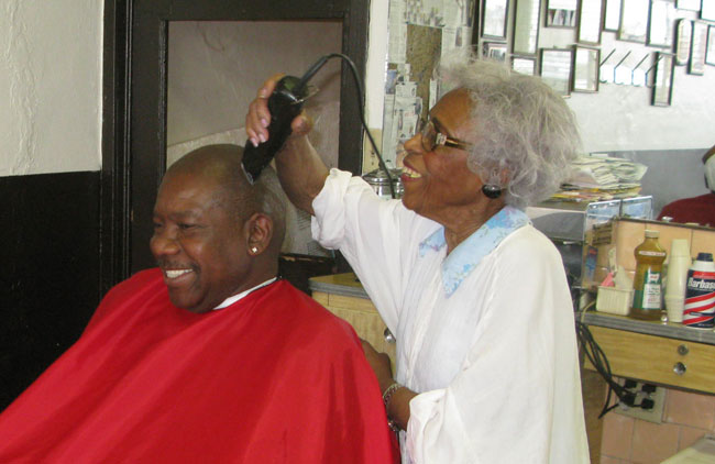 Barber Estine Davis taking care of Dr. Donald Phifer a customer of her for 25 years. (Eddie Delgado/Borderzine.com)