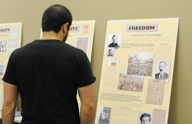 A student reads a poster dedicated to Padre Félix Varela and writer José Martí who published newspapers in the U.S. to support freedom in their countries of origin. (Lourdes Cueva Chacón/Borderzien.com)