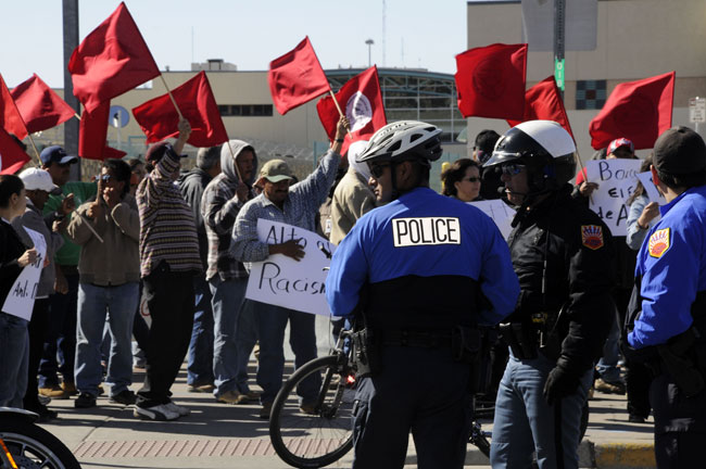 Manifestantes de la Asociación de Trabajadores Fronterizos enarbolan banderas rojas a la vez que reclaman justicia. (Jorge Jiménez, cortesía de El Diario de El Paso)