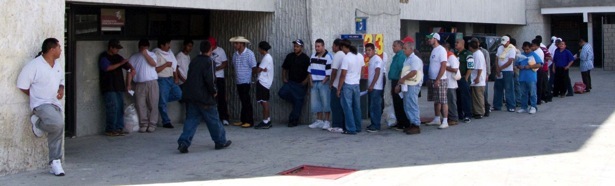 Deportees in line to make a free phone call at the office of Coordinación de Atención a Migrantes, Juárez. (David Smith-Soto/Borderzine.com)