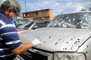 A police investigator looks for evidence following a drug-related hit in Hermosillo, Mexico. (Courtesy of Knight Foundation)