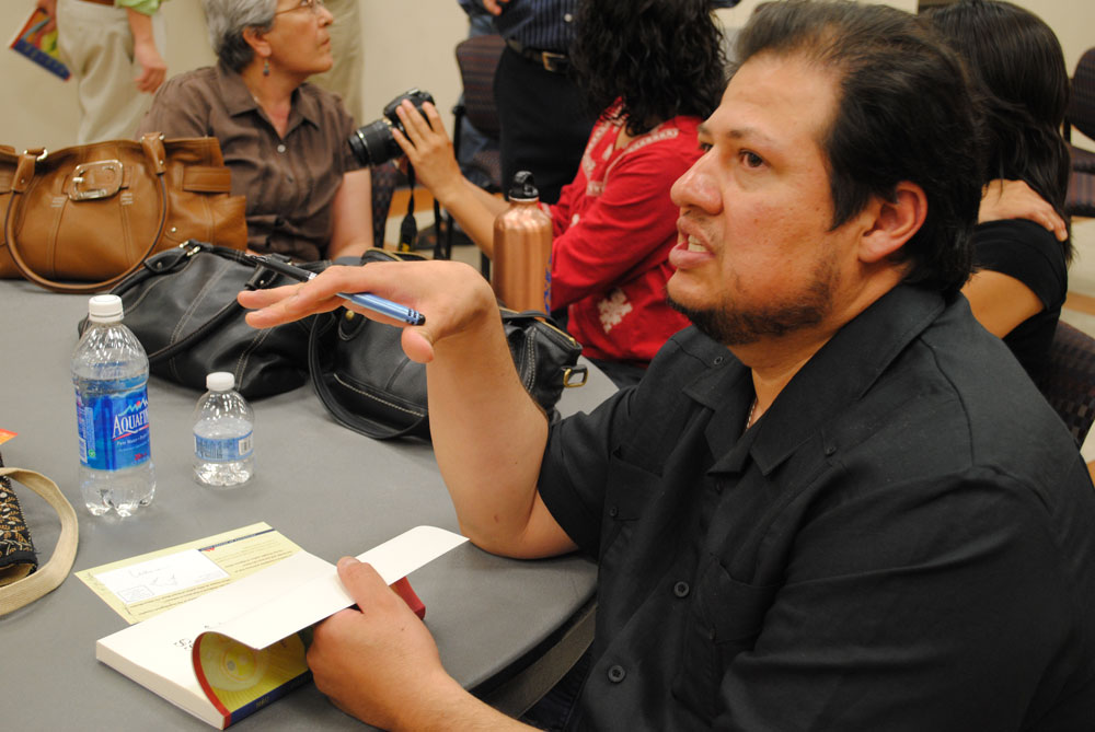 Richard Yanez, author of the novel “Cross Over Water” autographs a copy of his book during a signing at the UTEP campus Friday, April 22, 2011. (Miguel J. Cervantes/Borderzine.com)