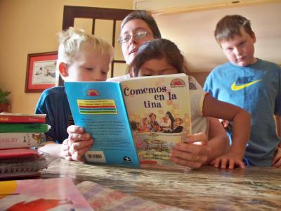 Karen Childress (center) teaches Foster and Susana to read in Spanish. (Collin Brooks/El Nuevo Tennessean)
