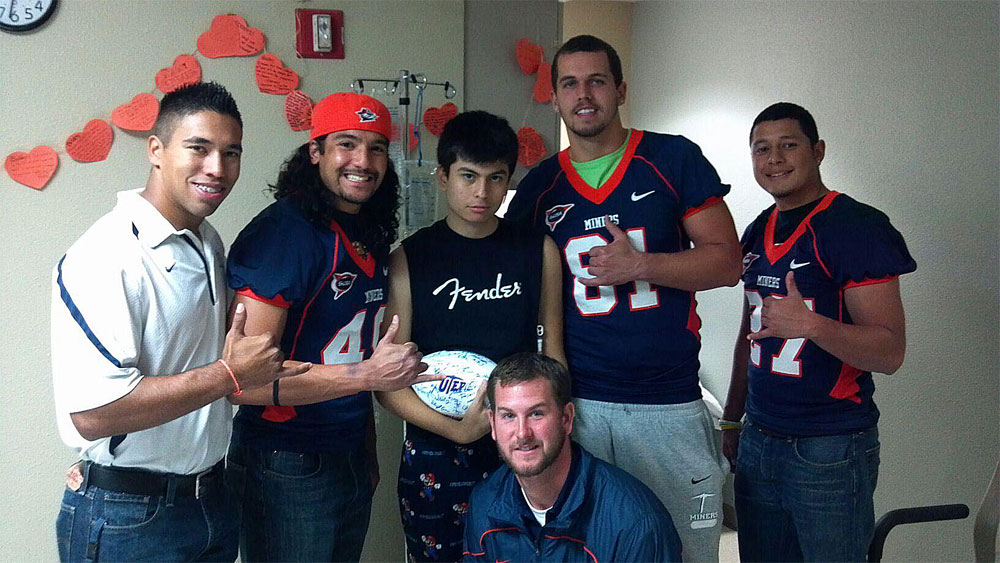 UTEP football team members visit Bobby (center) to give him a signed football while in the hospital. (Courtesy of Bobby Garcia)
