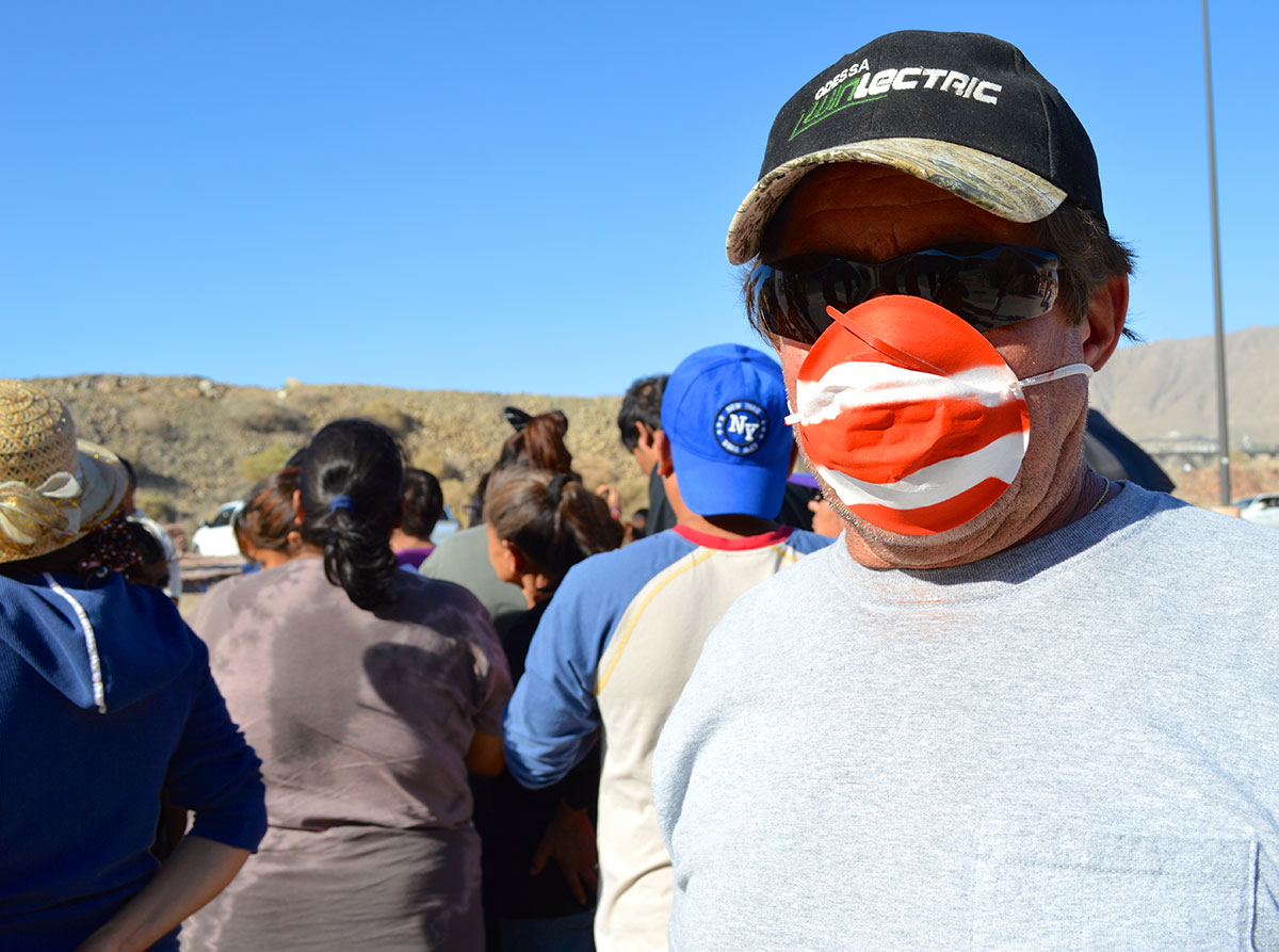 Lorenzo Najera wears a red and white mask as he protests. (Sarah A. Duenas/Borderzine.com)