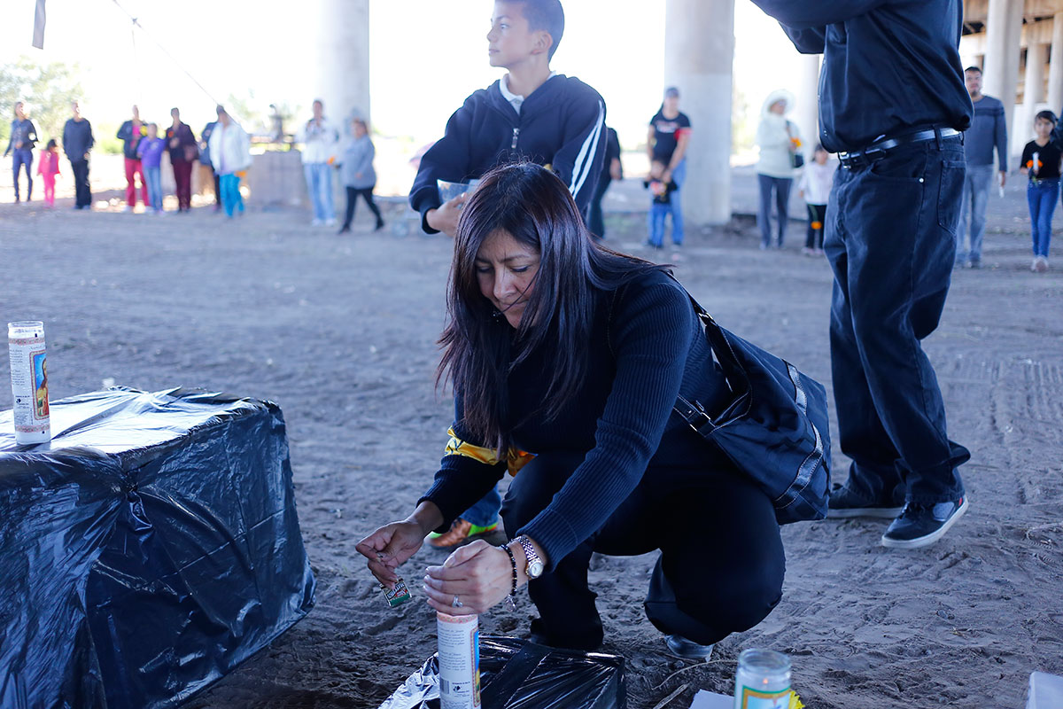 Beatriz Salazar lits a candle before the prayer commemorating the immigrants who died crossing the border. (Edwin Delgado/Borderzine.com)