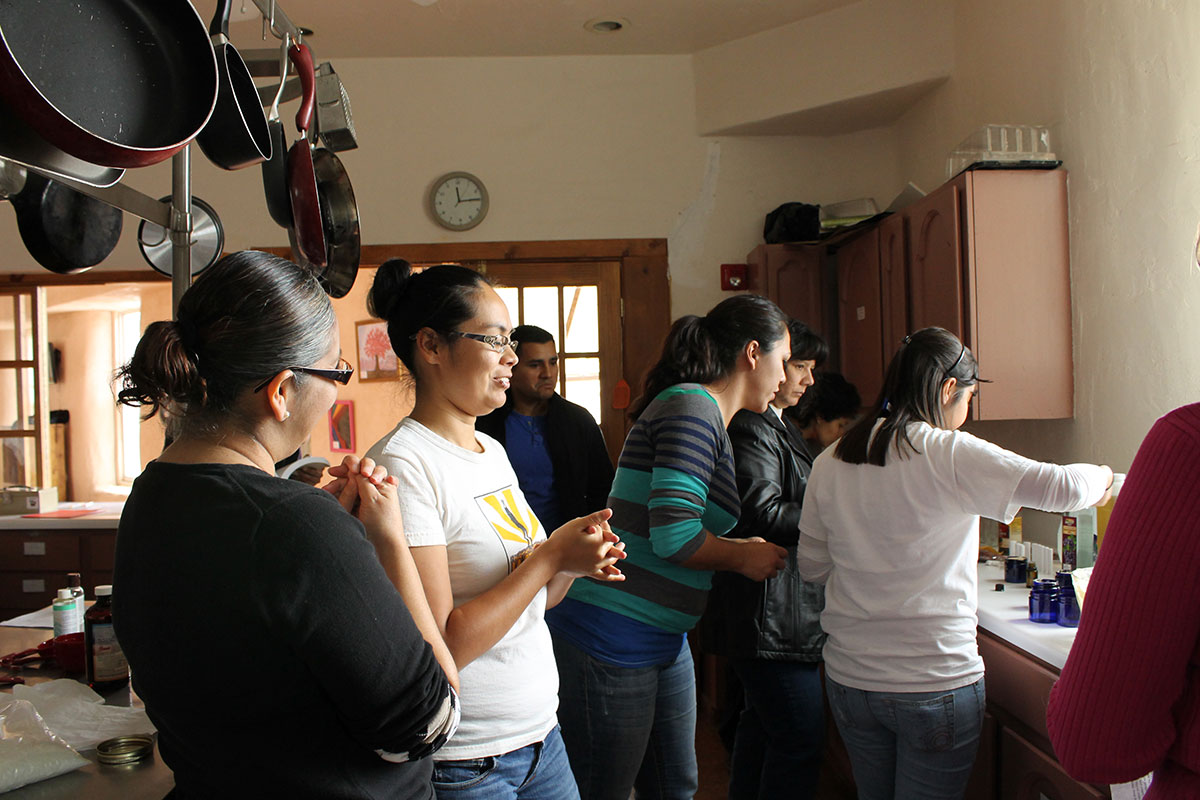 Catherine Yanez (white) and Krysten Aguilar (stripes) help during a DIY homemade gift workshop. (April Lopez/Borderzine.com)