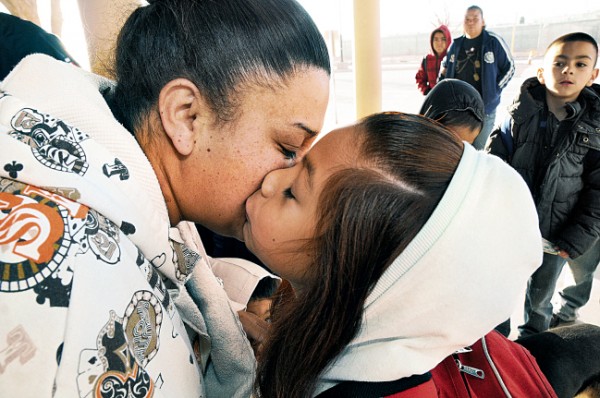 Anahi Martinez, 7, gives her mother Amanda Martinez a kiss goodbye under the Columbus Port of Entry canopy before entering the building to cross into the United States for school. (Robin Zielinski - Sun-News)