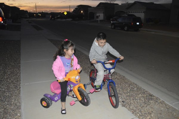 The Velarde children stay active riding bikes outdoors for playtime.