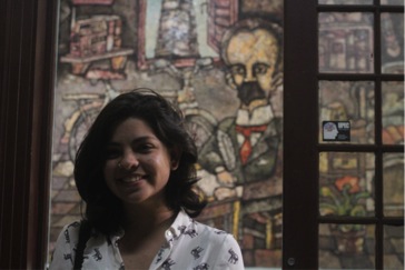 Daniella Fernandez in front of a mural of Independence hero Jose Marti inside the Instituto de Periodísmo Jose Martí in Havana.]