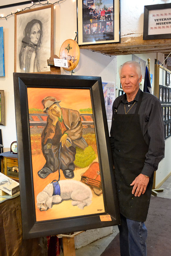 Manuel Alvarado with one of his art pieces at San Eli's art district. (Kimberly Garcia/Borderzine.com)