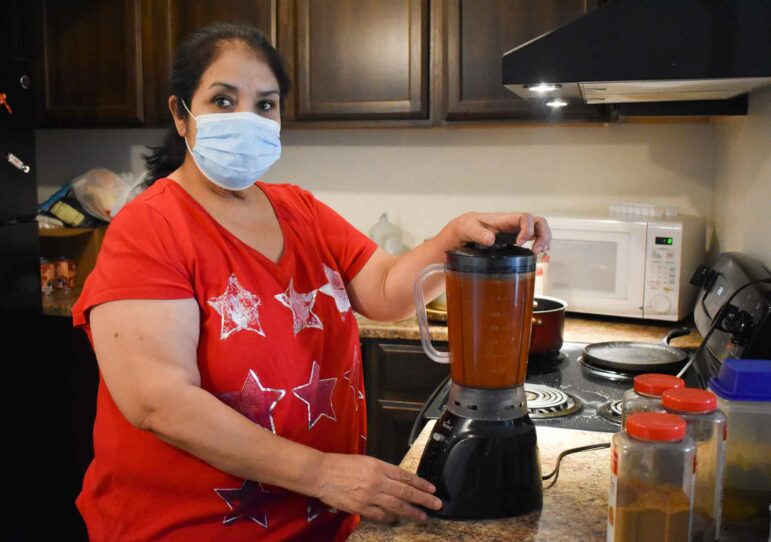 Elva “Raquel’ Salas blending the red chile sauce for the pozole she will sell. Photo by Emilia Zubia, Borderzine.com